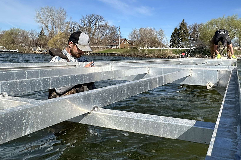 Technicians installing aluminum dock frame in West Central Minnesota lake.