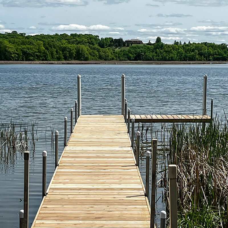 Wooden lake dock with side platform extension in West Central Minnesota.